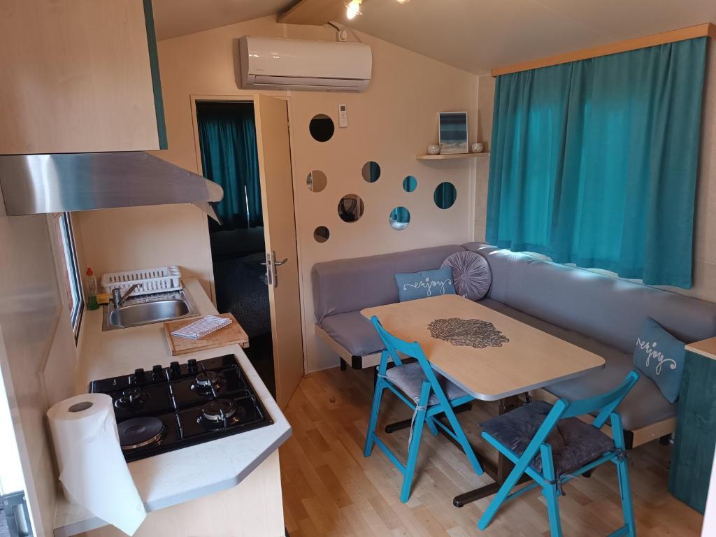 eine kleine Küche mit einem Tisch und einem Sofa in der Unterkunft Little house in Ražanac in Ražanac