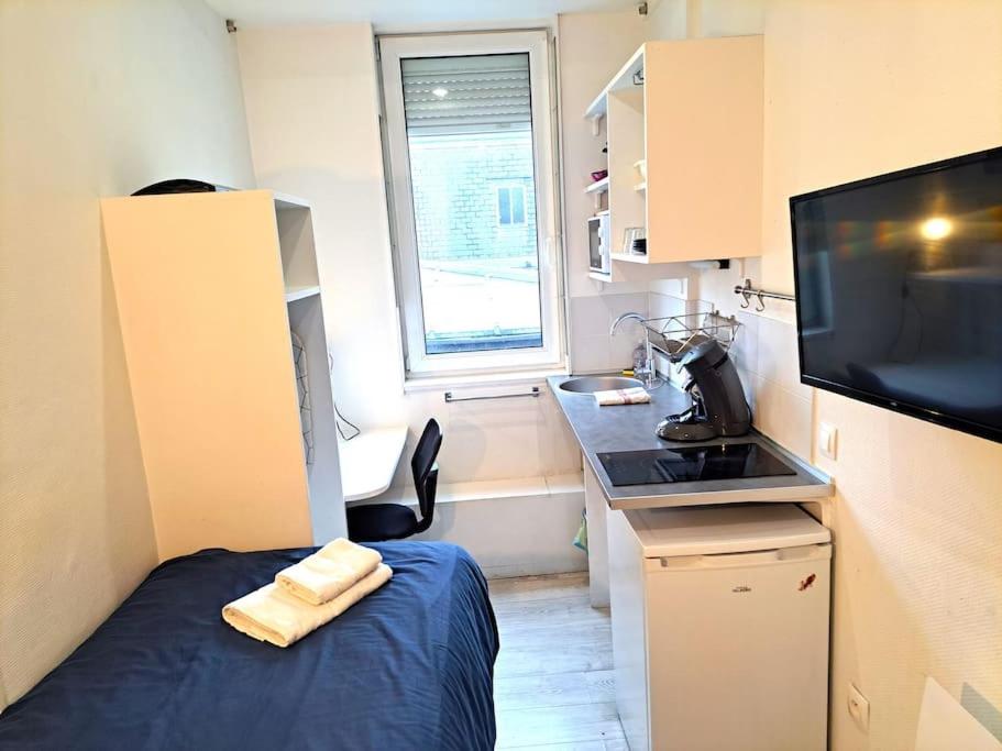 Cette petite chambre comprend un lit et une télévision. dans l'établissement Studette Vesle 4, à Reims