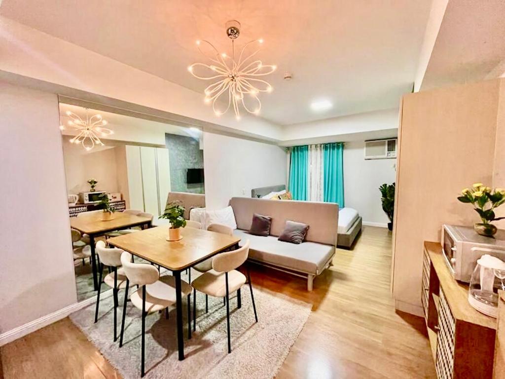 a living room with a couch and a table and chairs at Studio Type Condo City View 23rd F Abreeza Place in Davao City