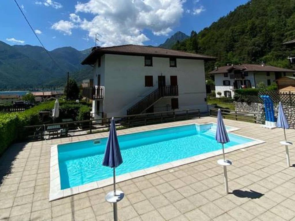 モリーナ・ディ・レードロにあるHoliday Home Val di Ledro near Lakeの家の前の傘付きスイミングプール