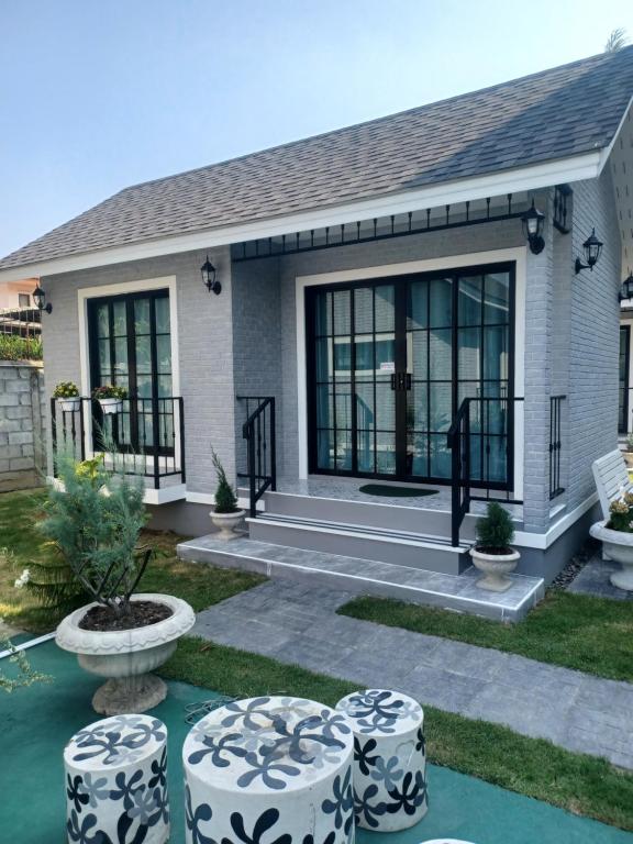 a house with large windows and stools in the yard at Zoom Garden Home in Nonthaburi