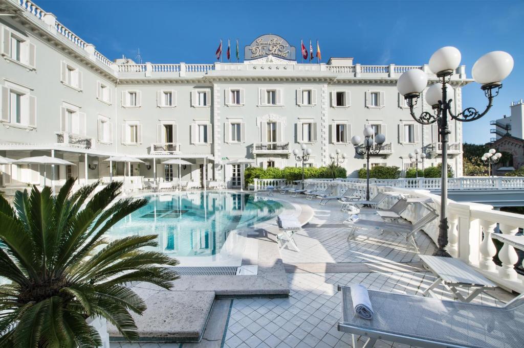 un hotel con piscina di fronte a un edificio di Grand Hotel Des Bains a Riccione
