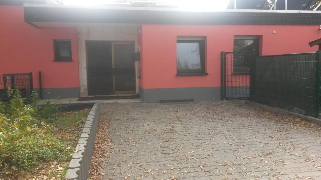 ein rotes Gebäude mit zwei Türen nebeneinander in der Unterkunft Gästezimmer Kelsterbach in Kelsterbach