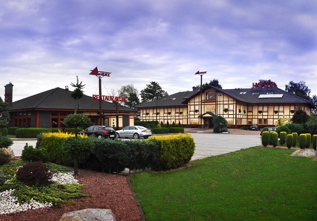 a hotel with cars parked in a parking lot at Ahotel in Czechowice-Dziedzice