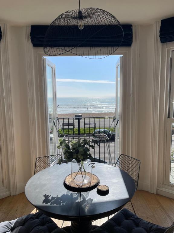 mesa de comedor con vistas al océano en Seaview flat with balcony, spacious 2 bedroom, en Worthing