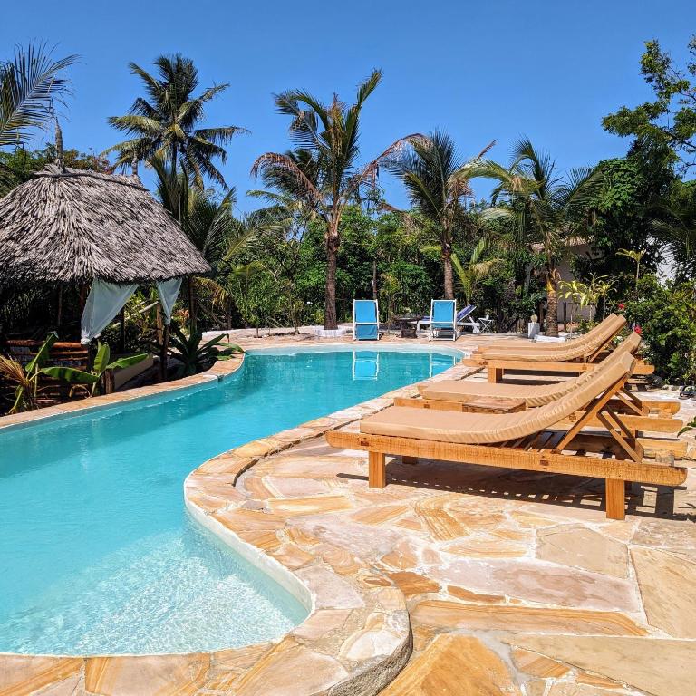 Una piscina con tumbonas y un resort. en Lala Land Lodge, en Kizimkazi