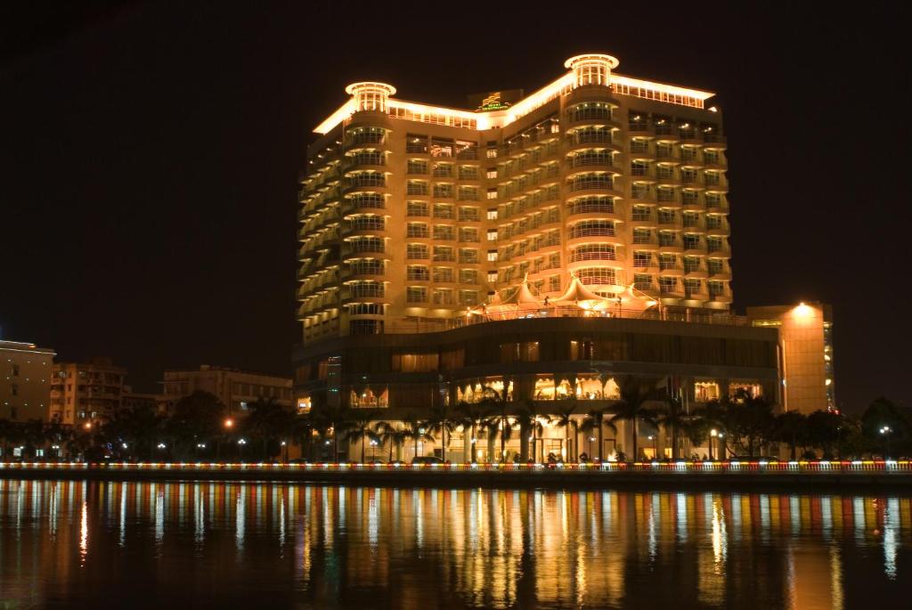 um grande edifício à noite ao lado de um corpo de água em Hiyet Oriental Hotel em Zhongshan