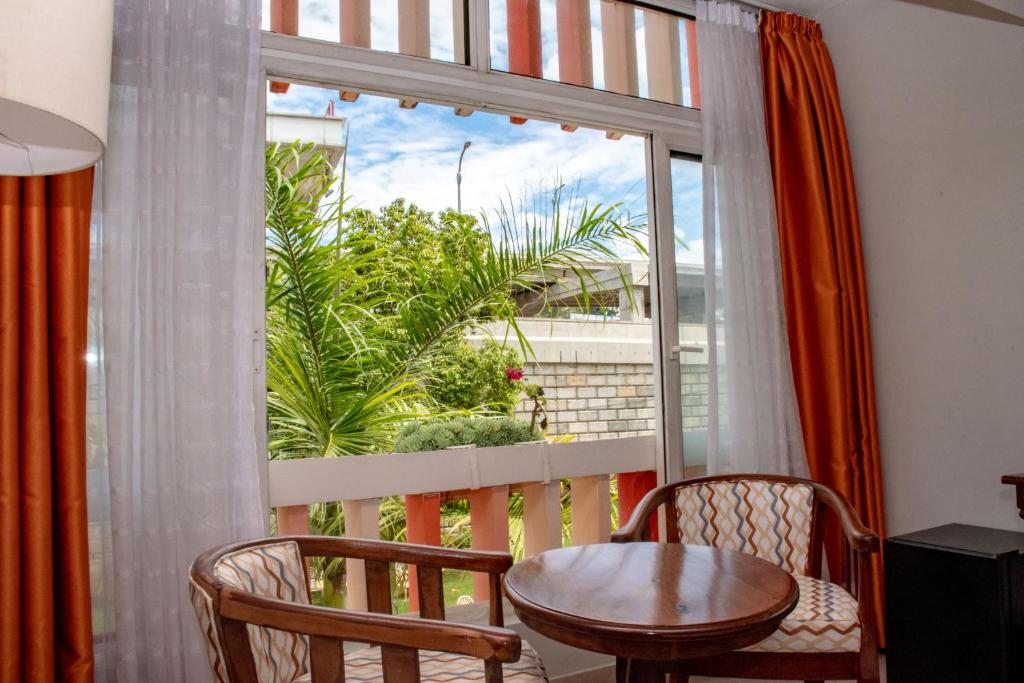 balcone con tavolo, sedie e finestra di Hotel Boulevard Nairobi, City Centre CBD a Nairobi