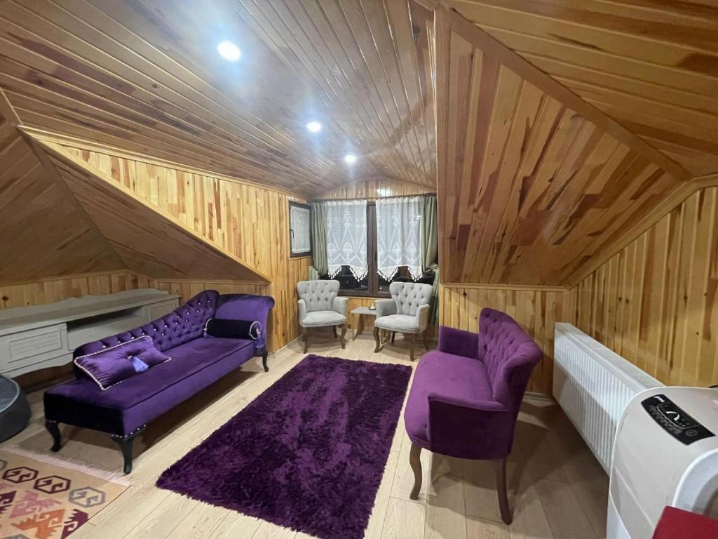 Habitación con muebles de color púrpura y paredes de madera. en Vinland Villa Atalar en Trebisonda