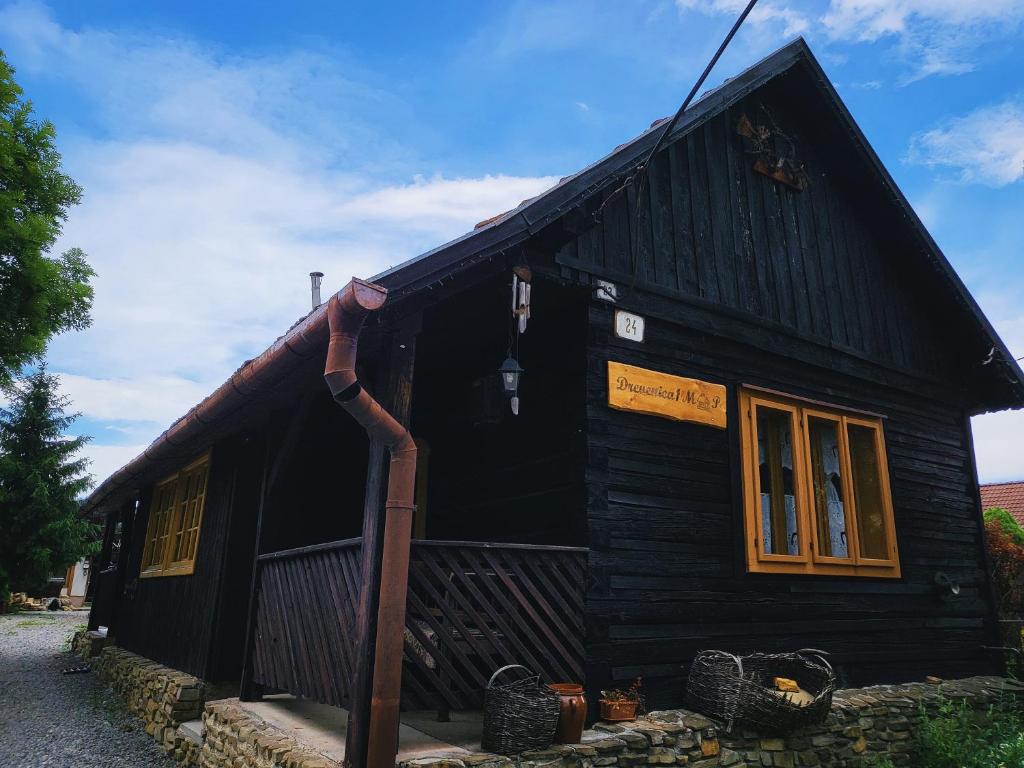 a small black house with a pipe at Drevenica M&P in Bešeňová