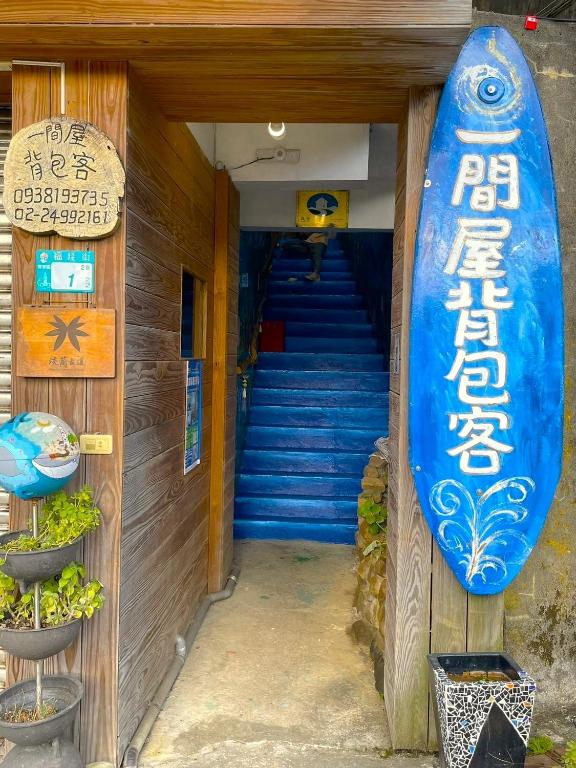 Una tabla de surf en el costado de un edificio con escaleras. en One House, en Gongliao