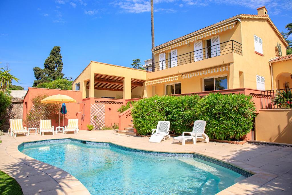 une maison avec une piscine devant une maison dans l'établissement Villa Cynthia - Piscine - Plage (à 50m) - Palais Congrès - Calme absolu, à Cannes