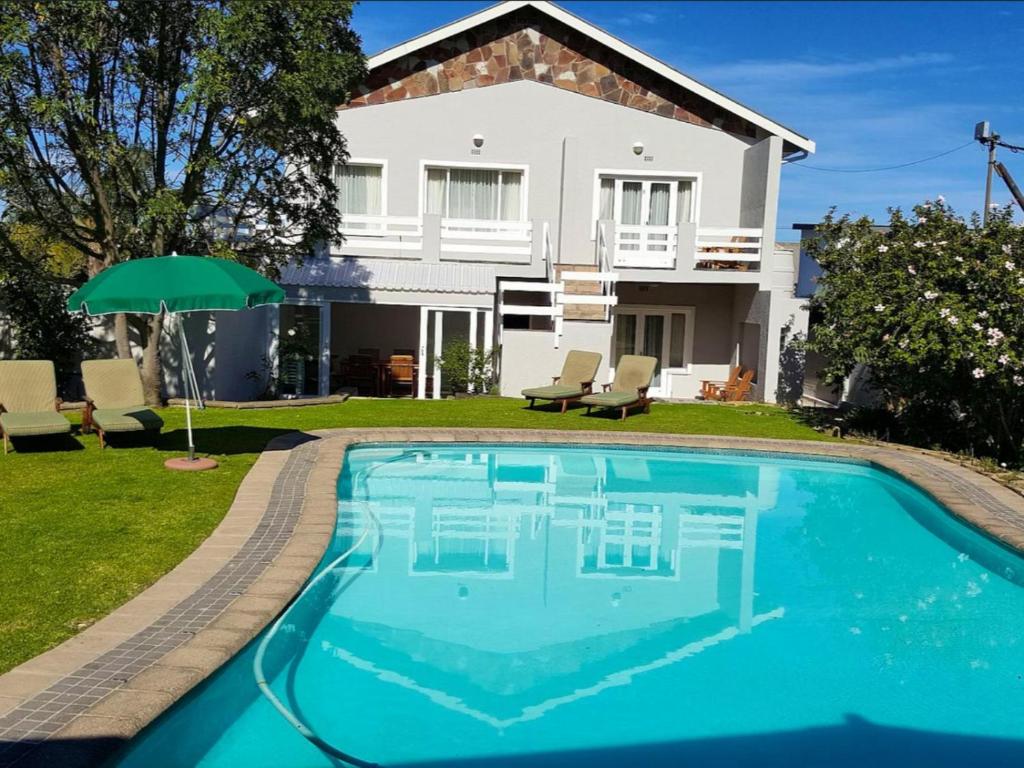 una casa con piscina delante de una casa en Moments Guesthouse, Kleinmond, en Kleinmond