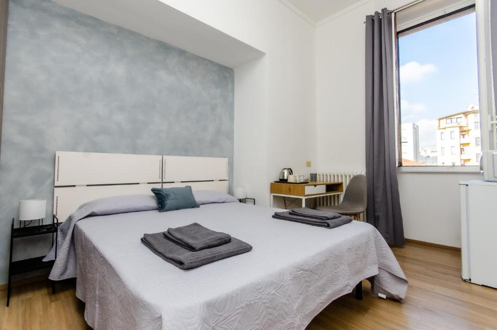 een slaapkamer met een groot bed en een groot raam bij Blue Room in Milaan