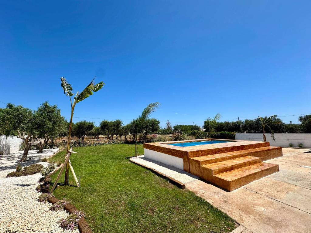 a backyard with a swimming pool and a palm tree at Villa Santo Stefano in Monopoli