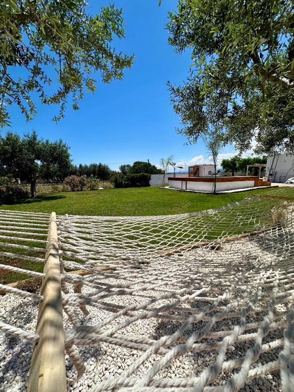 a hammock on a beach with a house in the background at Villa Santo Stefano in Monopoli