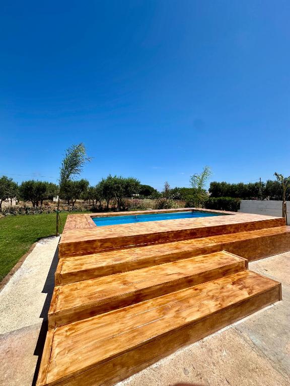 a wooden retaining wall around a swimming pool at Villa Santo Stefano in Monopoli