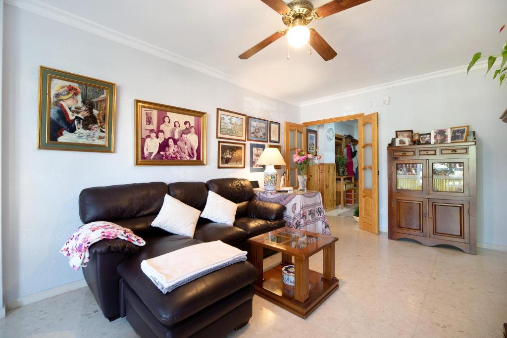 a living room with a leather couch and a table at Casa El Aguila en El Puerto in El Puerto de Santa María