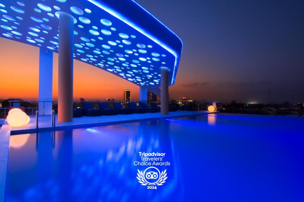 una piscina en la azotea de un edificio por la noche en SUN & MOON, Urban Hotel en Phnom Penh