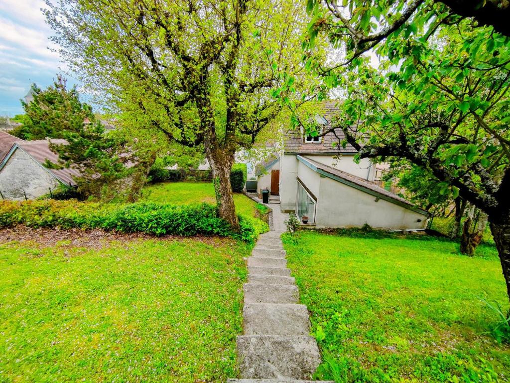 a stone path in a yard with a tree at La Petite Fontaine- Séjour à Migé in Migé
