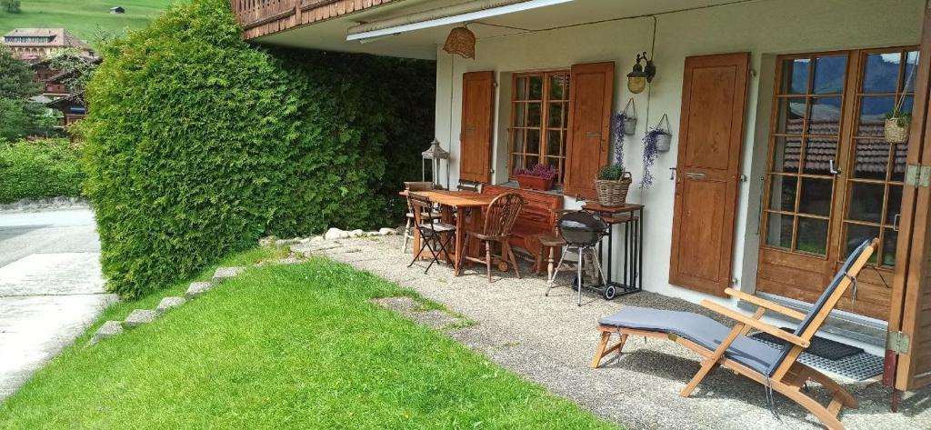 uma casa com uma mesa e cadeiras no quintal em Cozy apartment in the heart of the Alps em Château-d'Oex