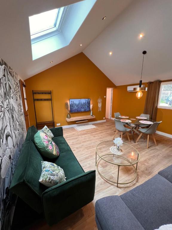 a living room with a green couch and a table at Maison T3 2CH Climatisée Terrasse parking gratuit in Saint-Julien-les-Villas