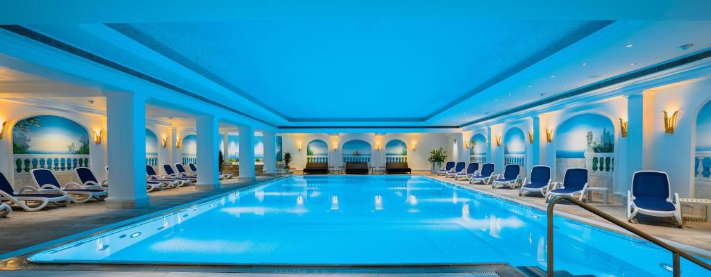 uma piscina num hotel com cadeiras em revita - naturresort & spa em Bad Lauterberg