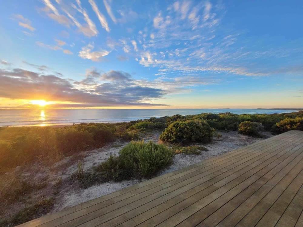 a sunset over the ocean with a wooden boardwalk at Long Beach Break in Robe