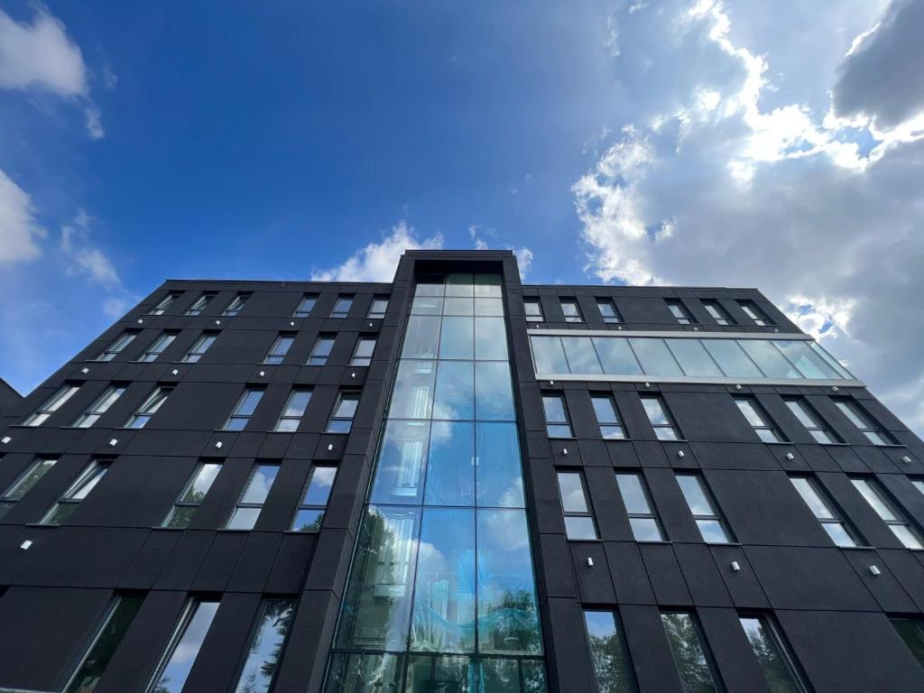ein hohes schwarzes Bürogebäude mit Glasfenstern in der Unterkunft Hotel Lantier Bytom - Katowice - Chorzów in Bytom