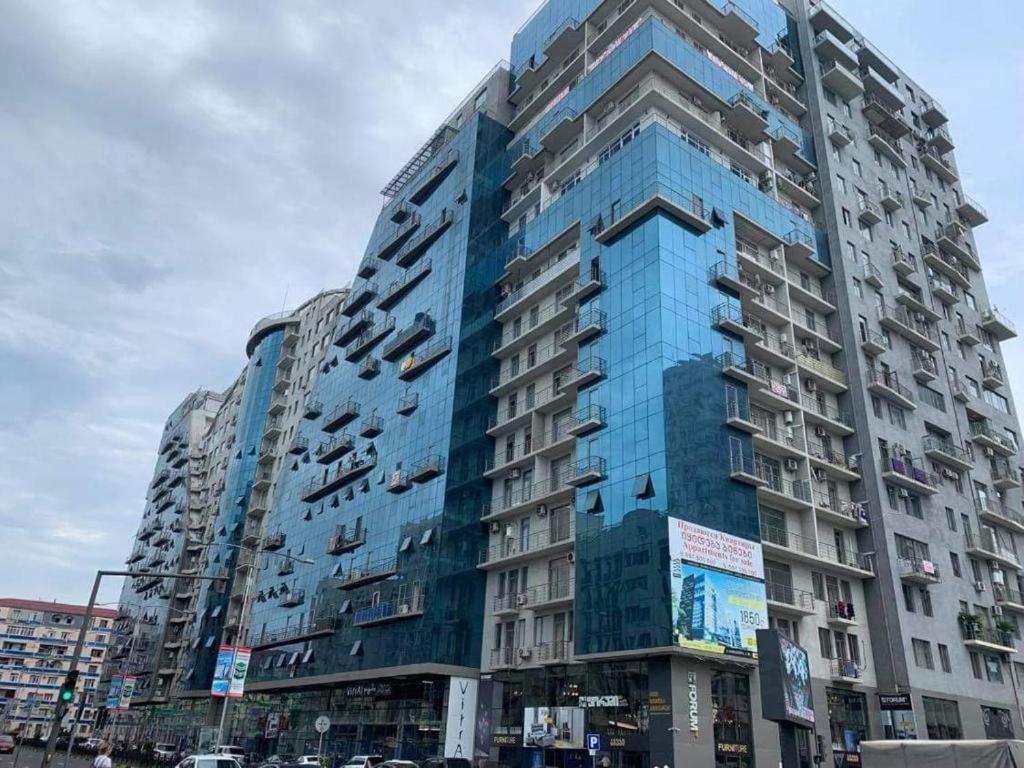 um edifício azul alto com muitas janelas em Seaside apartments em Batumi