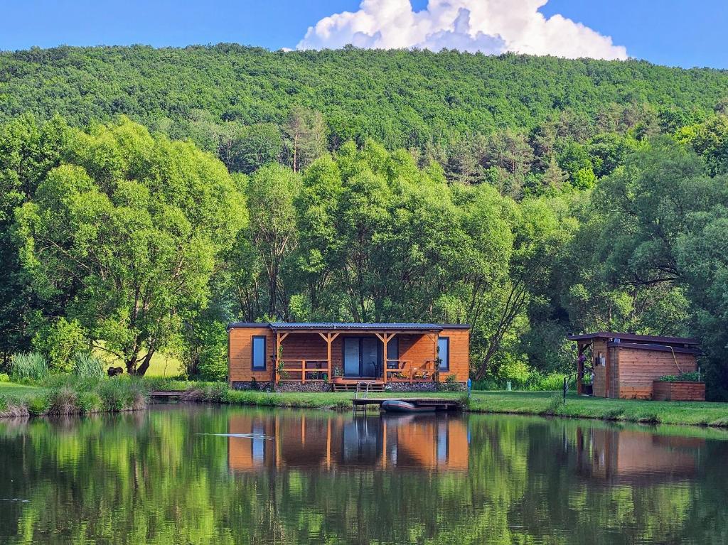 una casa al lado de un cuerpo de agua en Dom na jazere, en Pliešovce