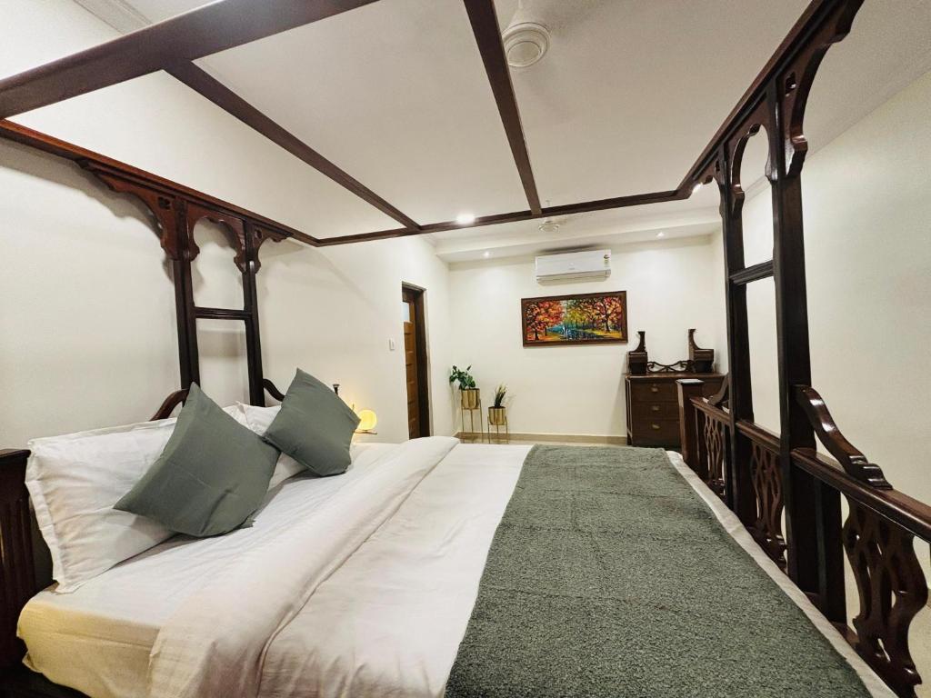um quarto com uma cama grande e almofadas verdes em CooCasa em Mahabaleshwar