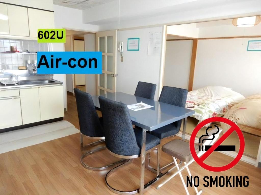 uma sala de jantar com uma mesa e cadeiras com um sinal para não fumadores em Ueda Building - Vacation STAY 8565 em Asahikawa