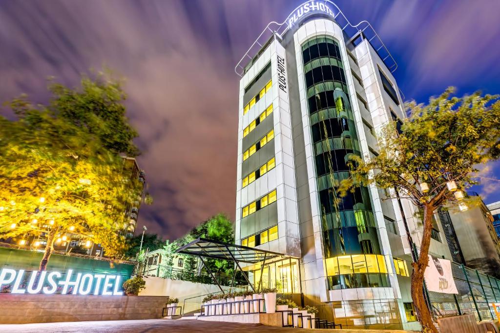 un edificio alto con un árbol delante de él en Plus Hotel Bostanci Atasehir, en Estambul