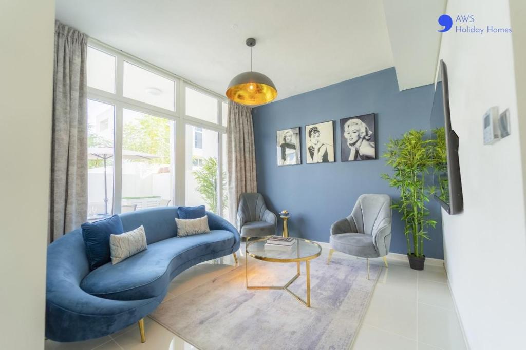 a blue living room with a blue couch and chairs at AWS Homes - Elegant Villa with BBQ Area & Garden in Dubai
