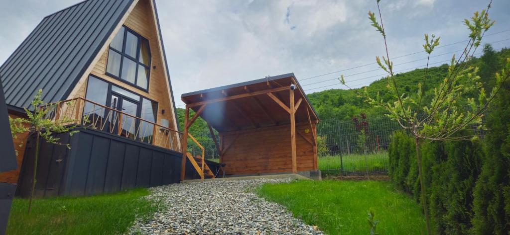 ein Haus mit einer Holztür und einer Kieseinfahrt in der Unterkunft E&T-Cabin A frame in Sibiu
