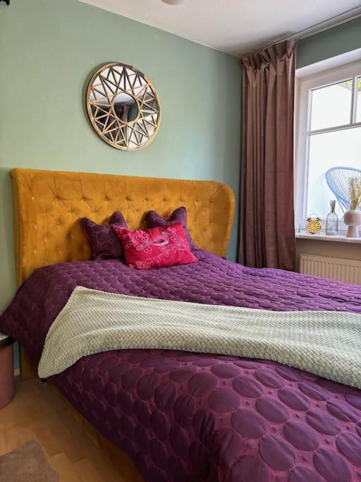 a purple bed in a bedroom with a window at Atelier Farbenreich No 8 in Eching