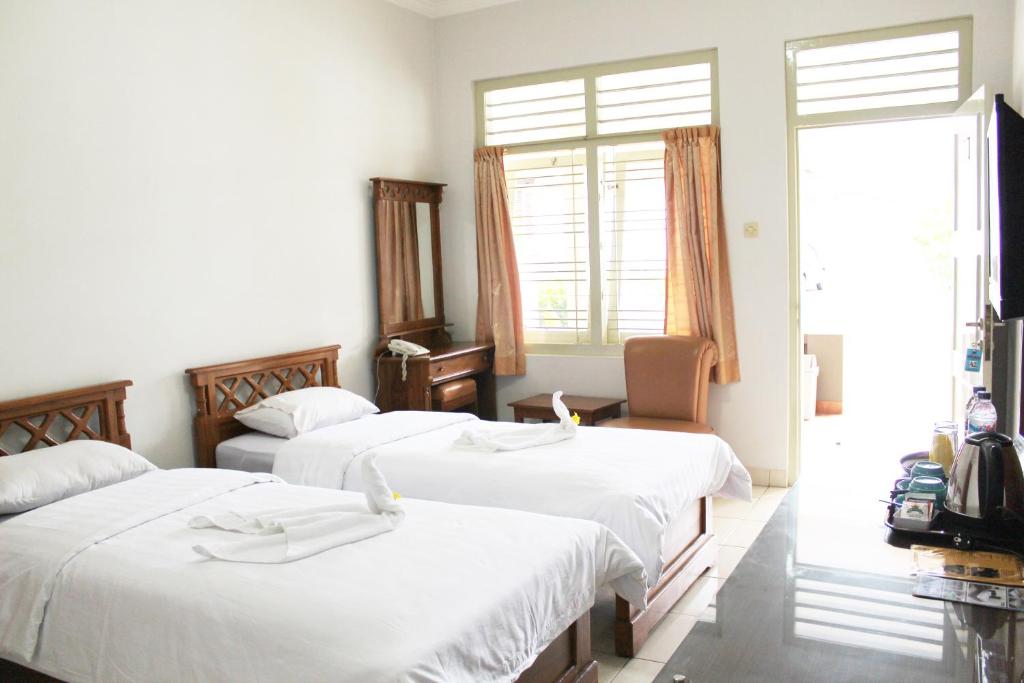 Postel nebo postele na pokoji v ubytování Hotel Besar Purwokerto