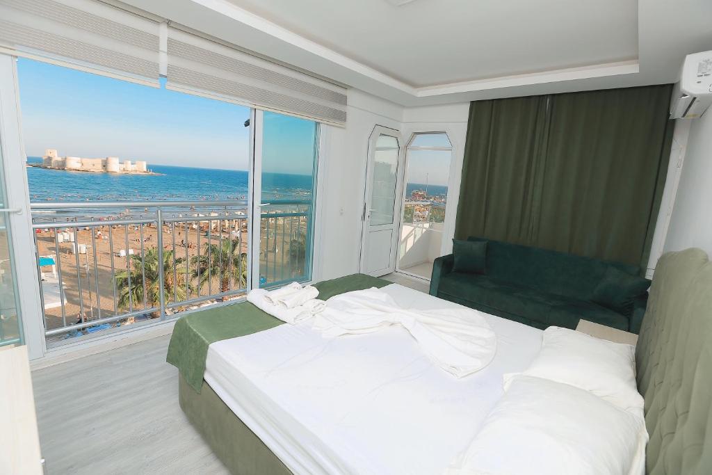 a bedroom with a bed and a view of the ocean at Angel Beach Hotel Kızkalesi Mersin in Erdemli