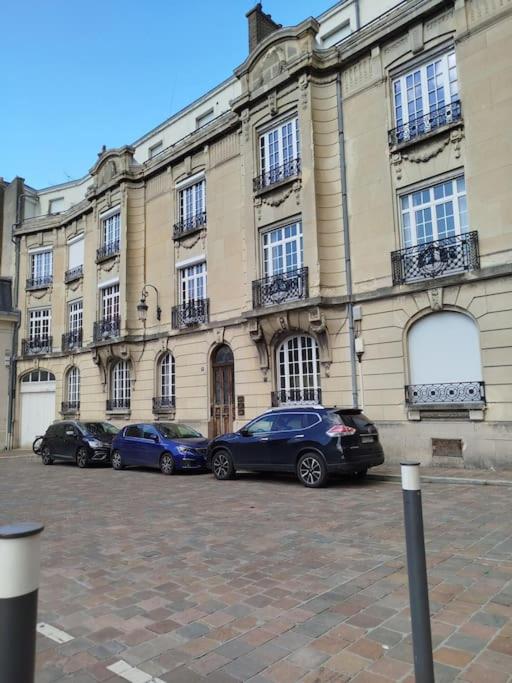 un groupe de voitures garées devant un bâtiment dans l'établissement Studette Cathédrale, à Reims