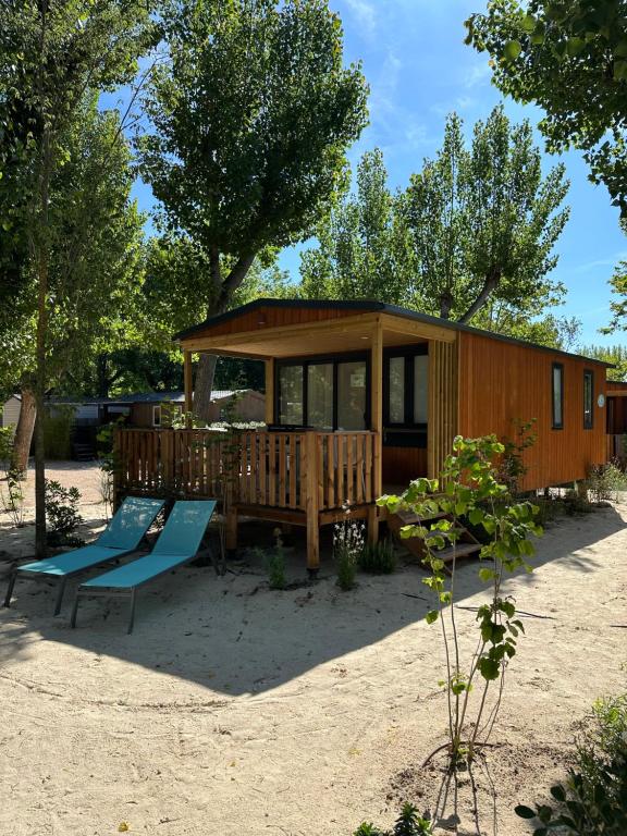 una casa pequeña con terraza y banco en Var Mobil Home, Les Prairies de la Mer en Grimaud
