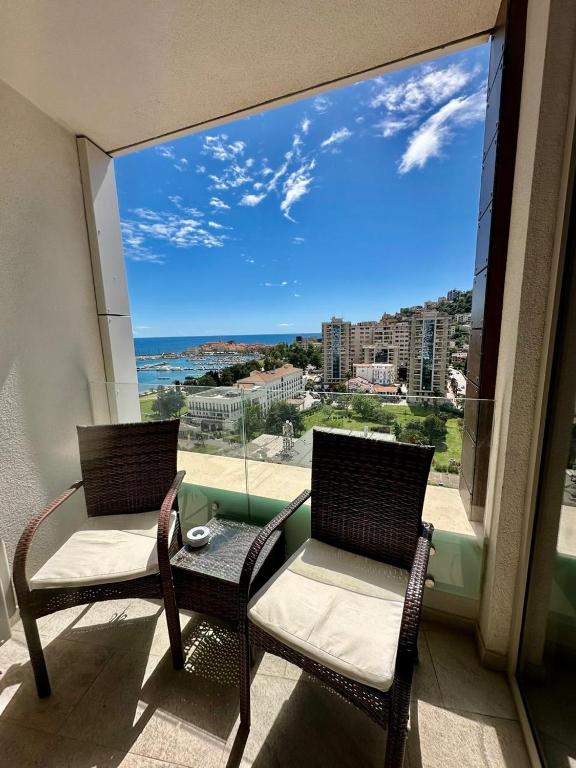 a balcony with two chairs and a view of the ocean at Apartman Drobnjak Center-sea View in Budva