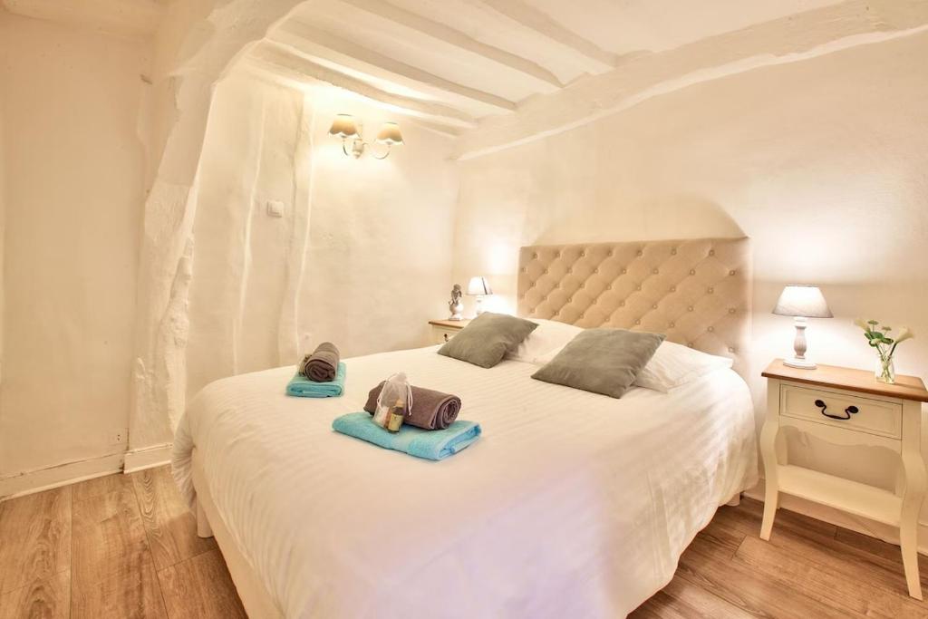 - une chambre dotée d'un lit blanc avec deux sacs dans l'établissement L Hibiscus 1, à Rouen