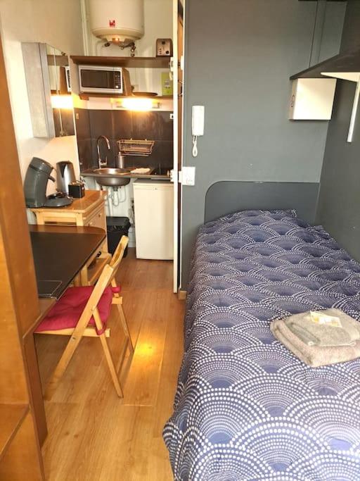 une petite chambre avec un lit et un bureau dans l'établissement Studette Place Jamot, à Reims