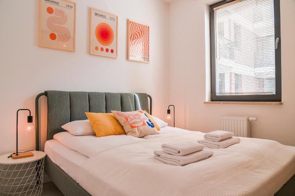 - une chambre avec un lit et des serviettes dans l'établissement CITYSTAY Garden Gates Apartment, à Gdańsk