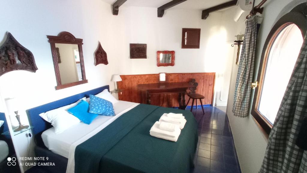 a bedroom with a bed with blue pillows and a desk at Villa con Piscina Privata fronte Spiaggia in Santa Marinella