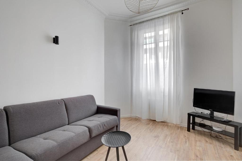 un salon avec un canapé et une télévision dans l'établissement 570 Suite Bloom - Superbe Appartement à Paris, à Paris