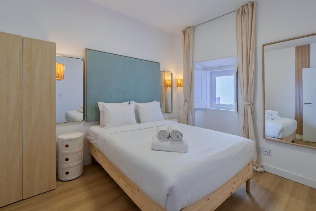 una camera da letto con un letto grande con asciugamani sopra di Fonz Patio House a Setúbal
