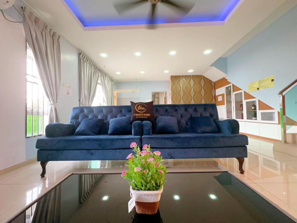 a blue couch in a living room with a potted plant at A05 Tebrau Austin 1 in Johor Bahru