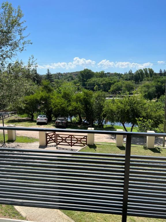 uitzicht op een park met een bank en een brug bij Balcón al río in Villa Carlos Paz